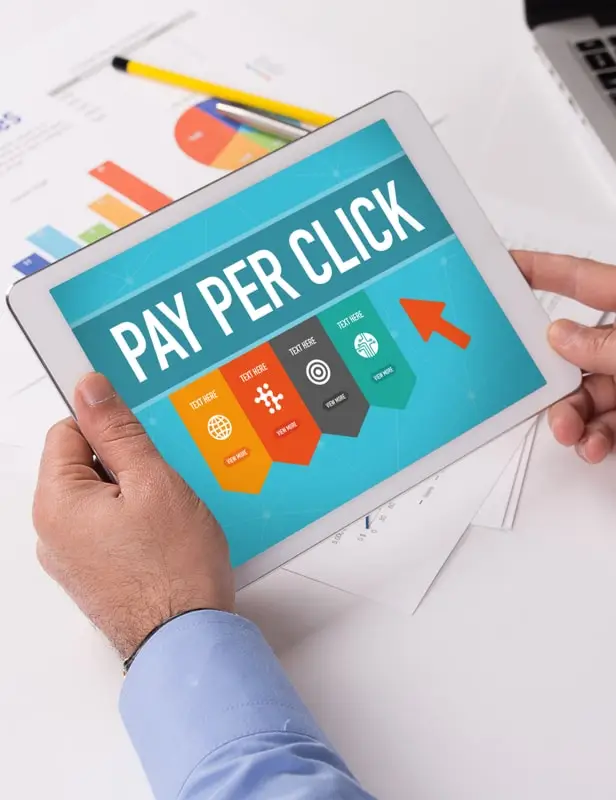 a marketer holding a tablet displaying pay per click graphic reflecting google adwords