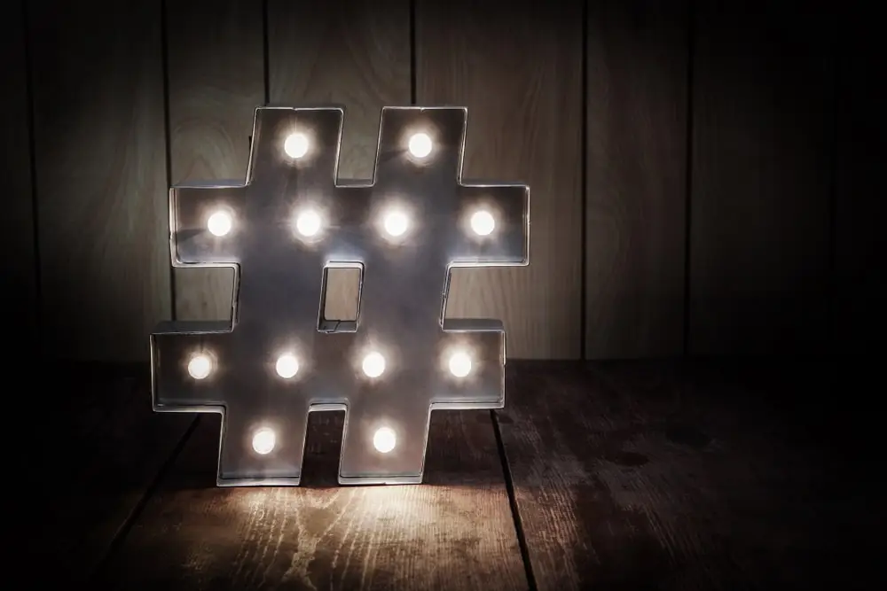 a lit up hashtag symbol against a wood background